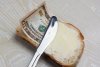 12812044-butter-and-money-on-a-slice-of-bread-and-knife.jpg
